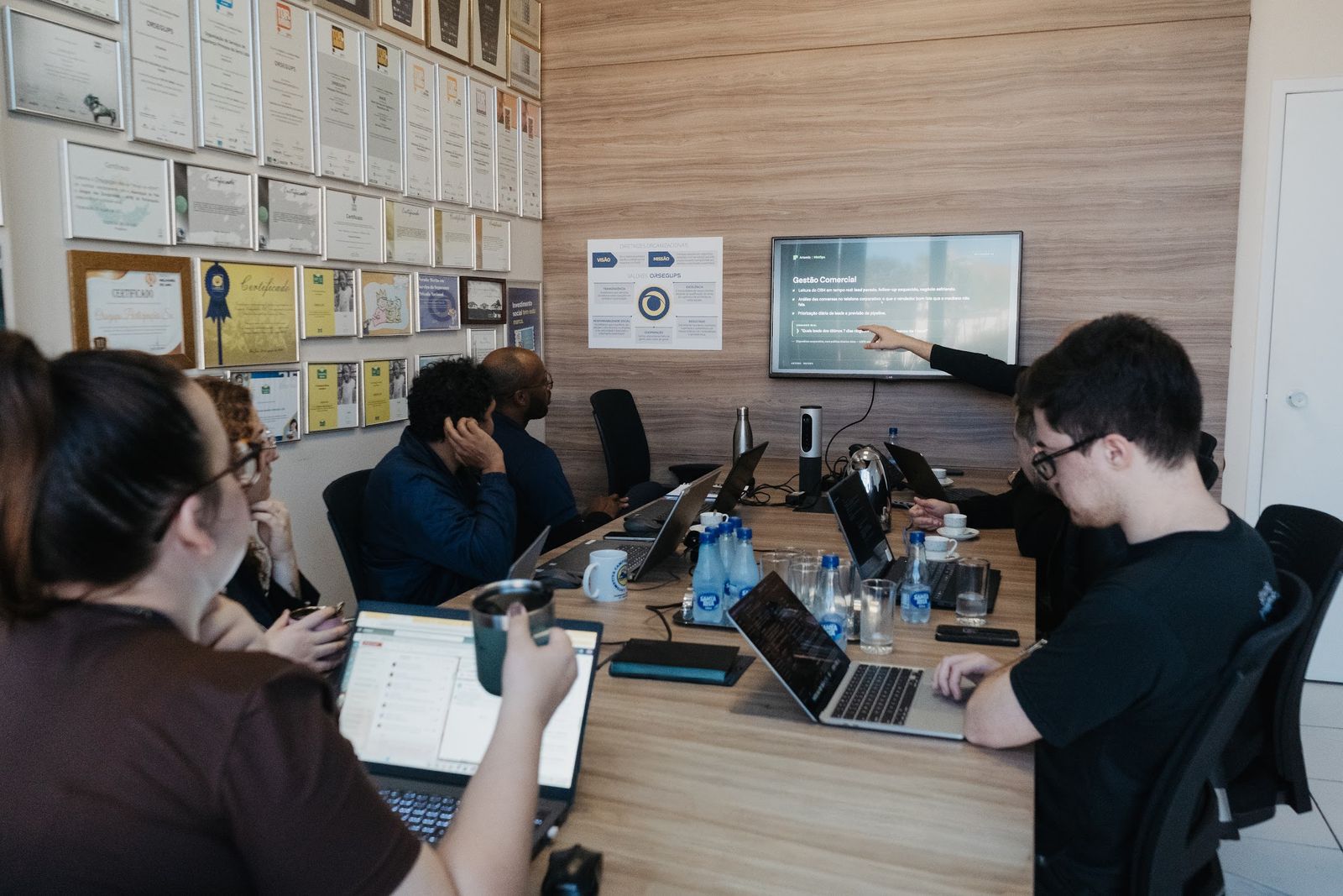 Time da Artemis reunido com um cliente numa mesa de trabalho