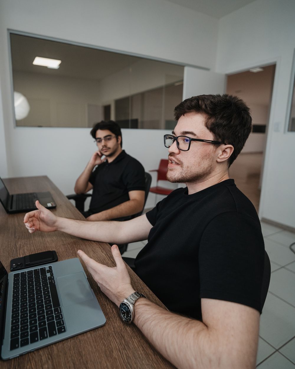 Dois integrantes do time conversando na mesa de reunião